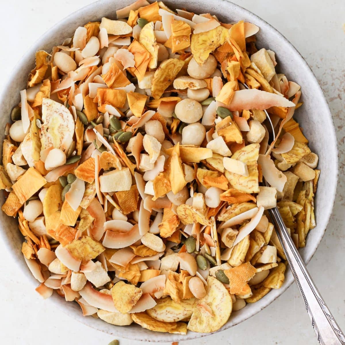 trail mix in a glass jar with almonds and chocolate chips